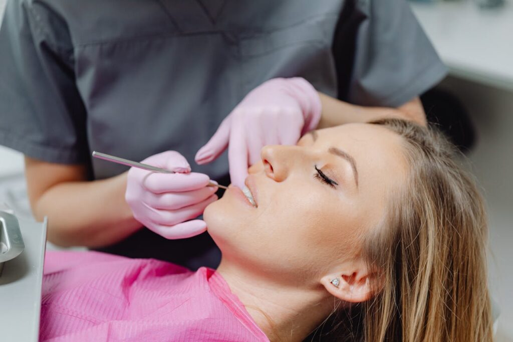 Home A female patient receives a dental examination by a dentist in a clinic.