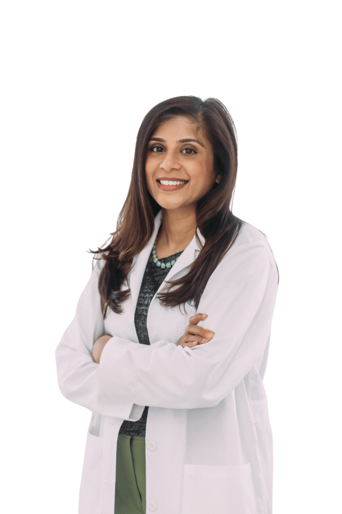Dr. Reshma Patel smiling while standing with her arms crossed.